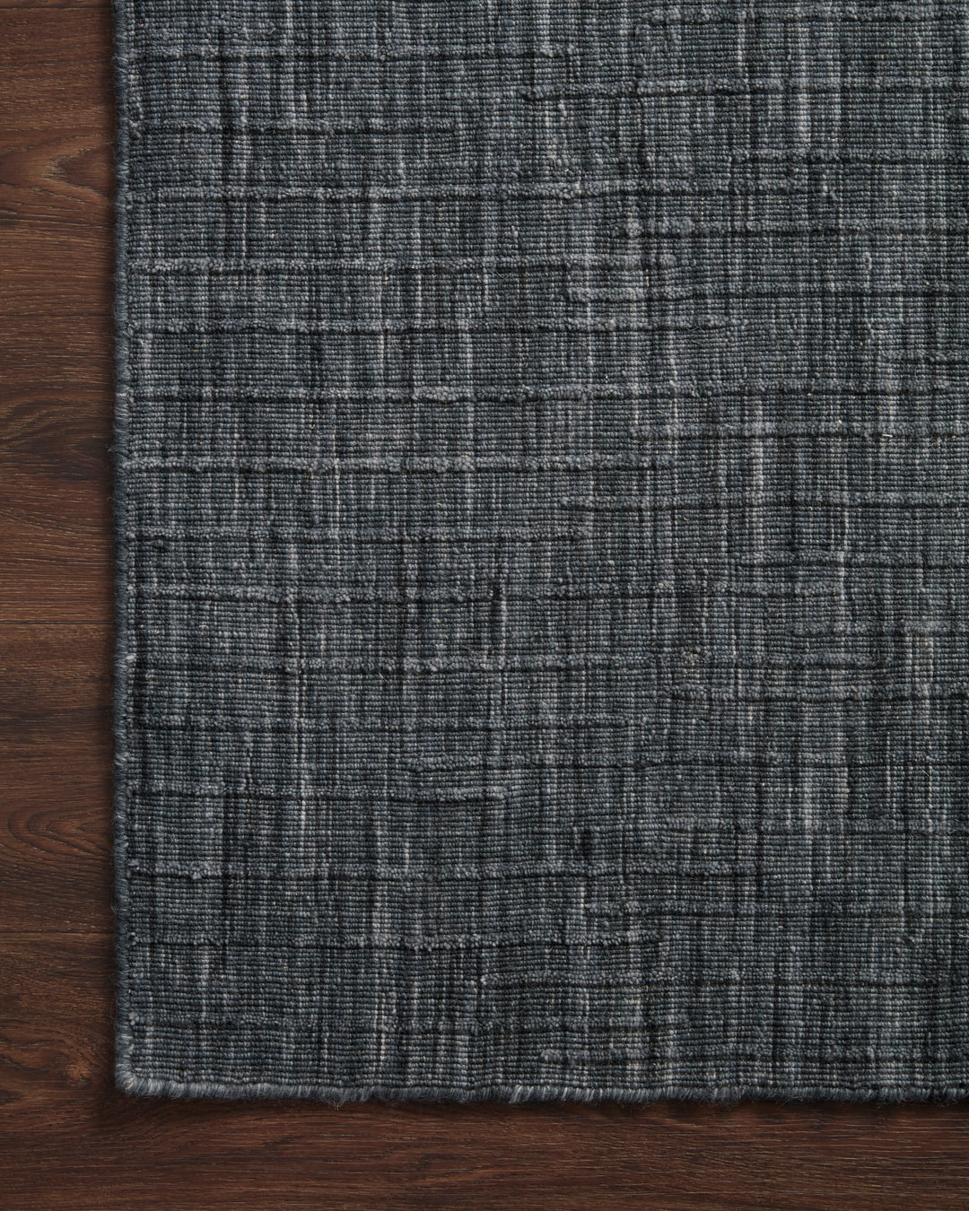 Textured dark blue gray rug on a wooden floor