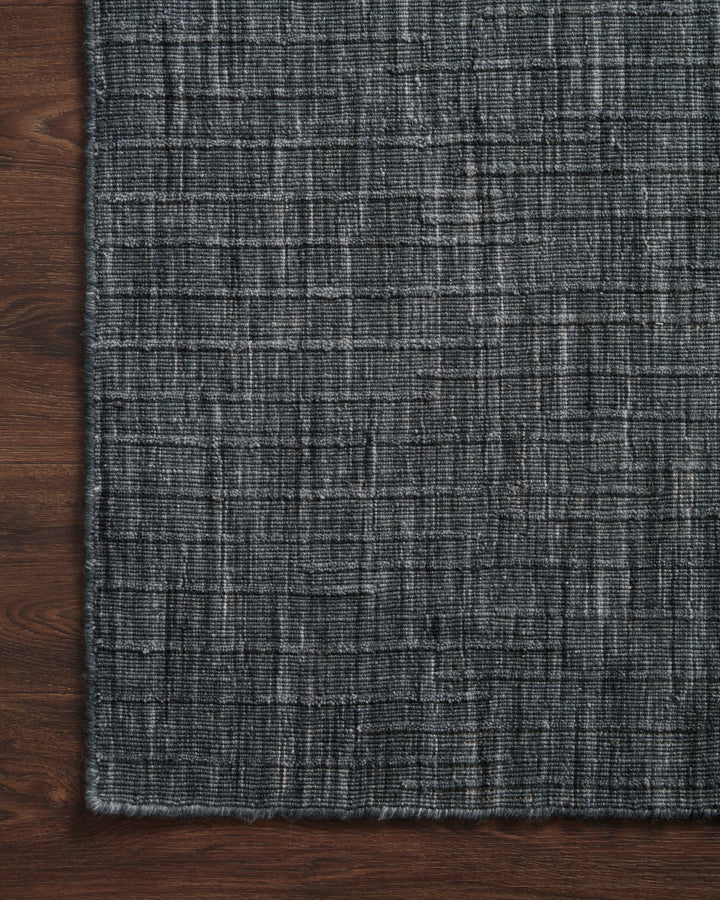 Textured dark blue gray rug on a wooden floor