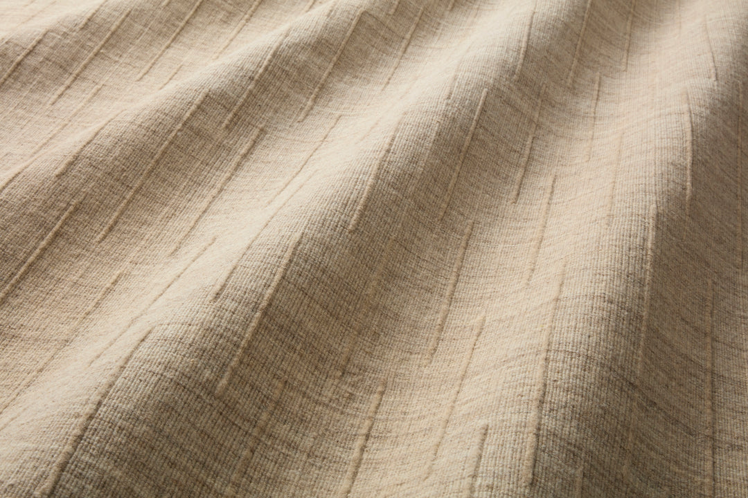Close-up of Brooks textured beige area rug made from wool with a raised minimal pattern
