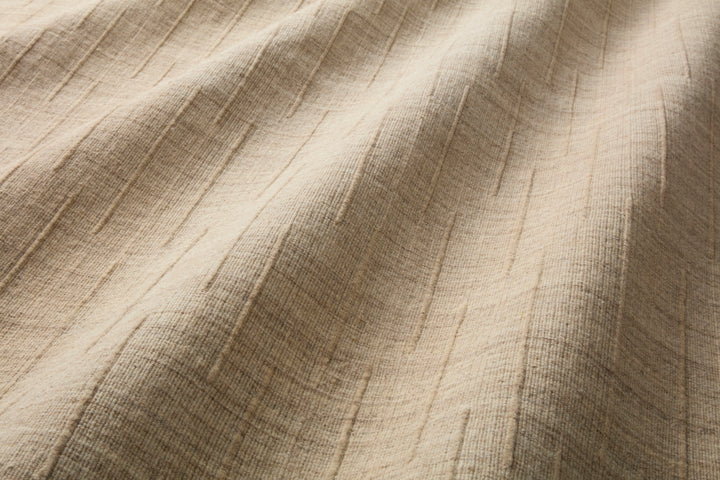Close-up of Brooks textured beige area rug made from wool with a raised minimal pattern