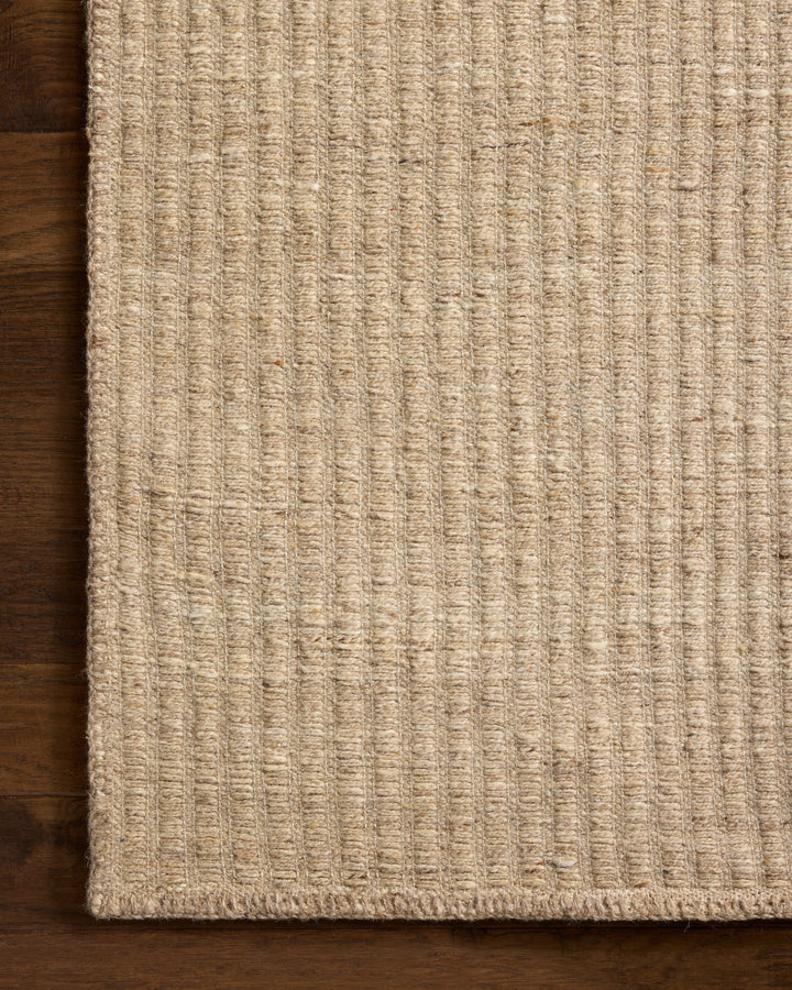 Textured beige rug on a wooden floor