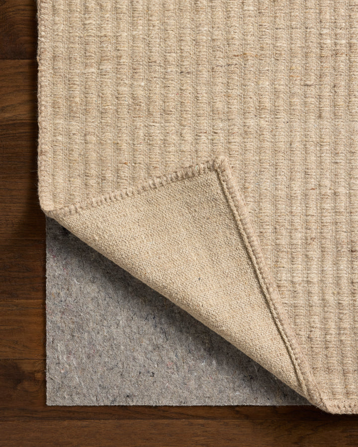Close-up of a beige textured rug on a wooden floor