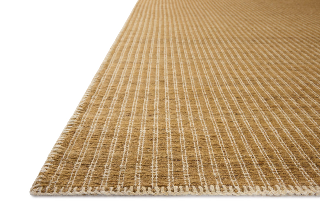 Close-up of a textured Elm Wheat beige rug with white stitching on a white background