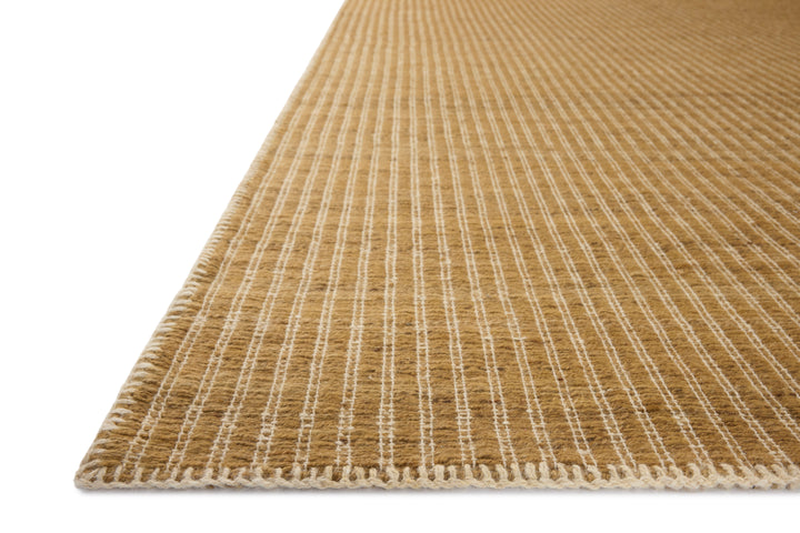 Close-up of a textured Elm Wheat beige rug with white stitching on a white background