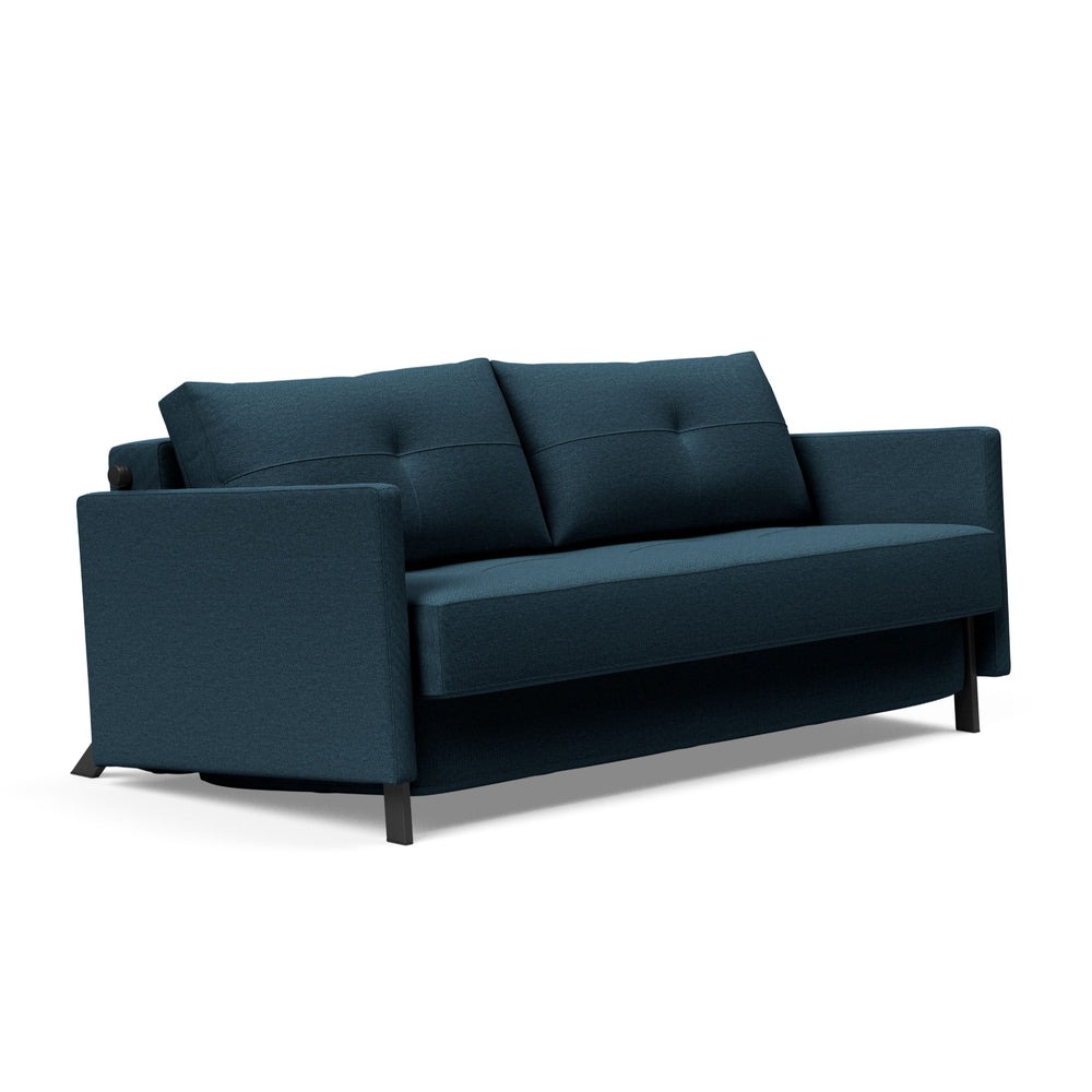 A compact queen-sized upholstered sofa bed in a blue color with visible tufted backrests and dark wooden legs.
