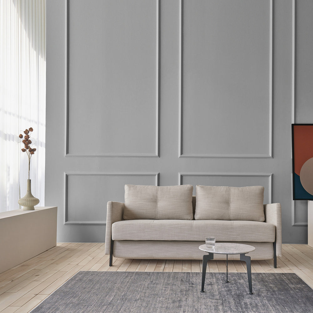 Stretch sofa bed in natural tweed. Compact in a modenr high ceiling room with a grey area rug